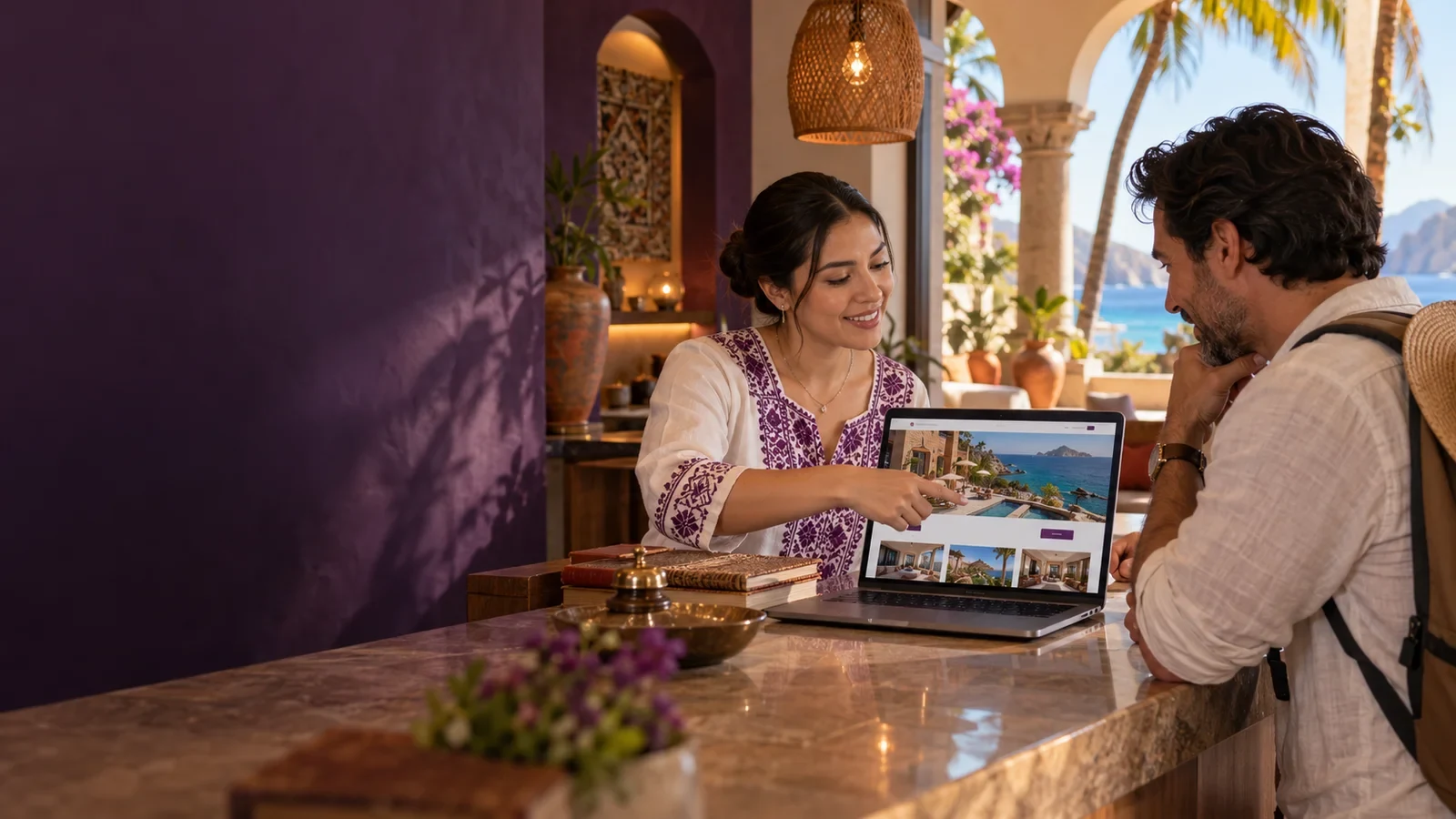 Recepcionista de hotel mostrando el sitio web de reservaciones a un huésped